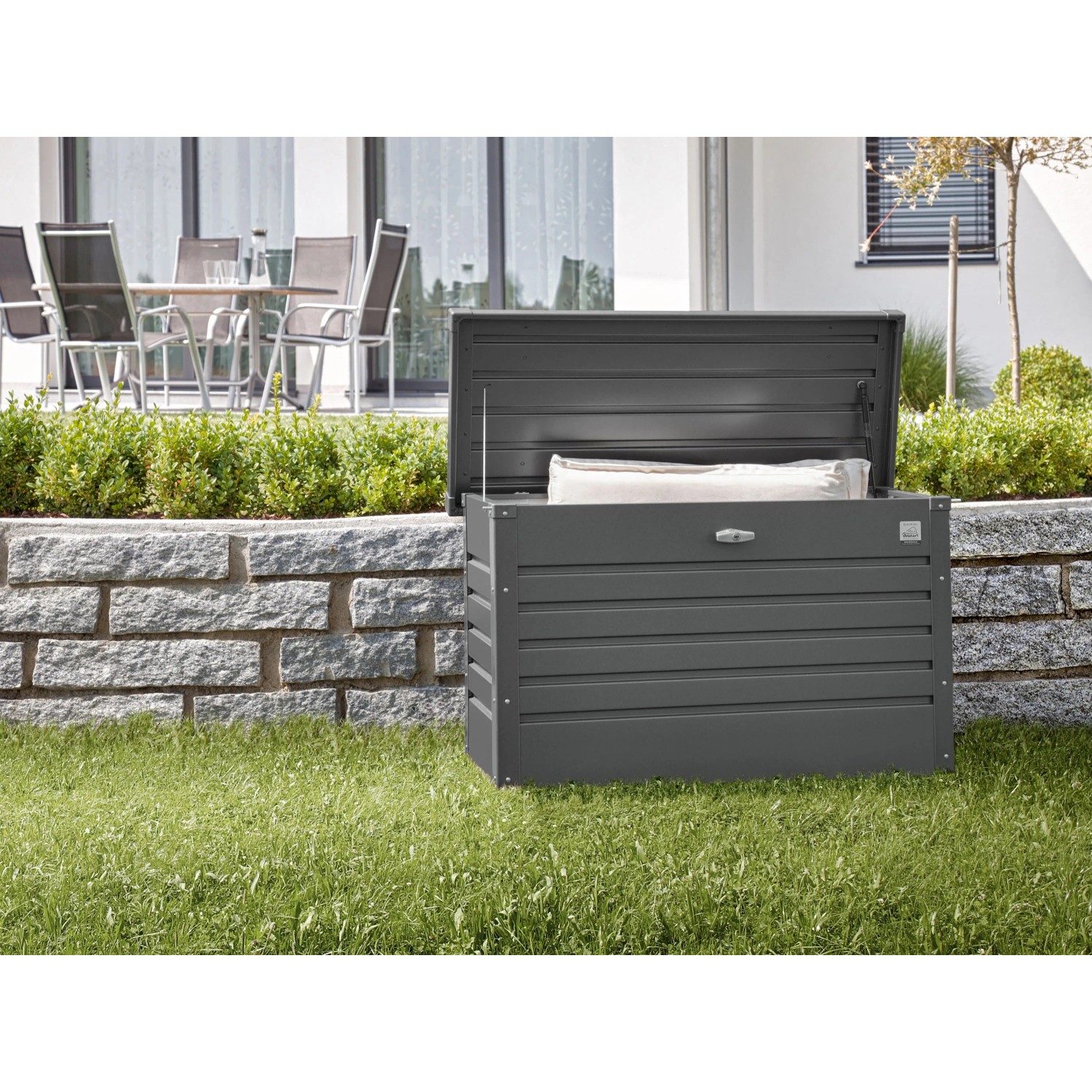 Biohort Box da giardino 130, grigio scuro metallizzato, con coperchio aperto in giardino.