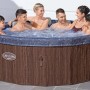 Vasca idromassaggio gonfiabile t.b.t. con persone in acqua, esterno effetto legno.