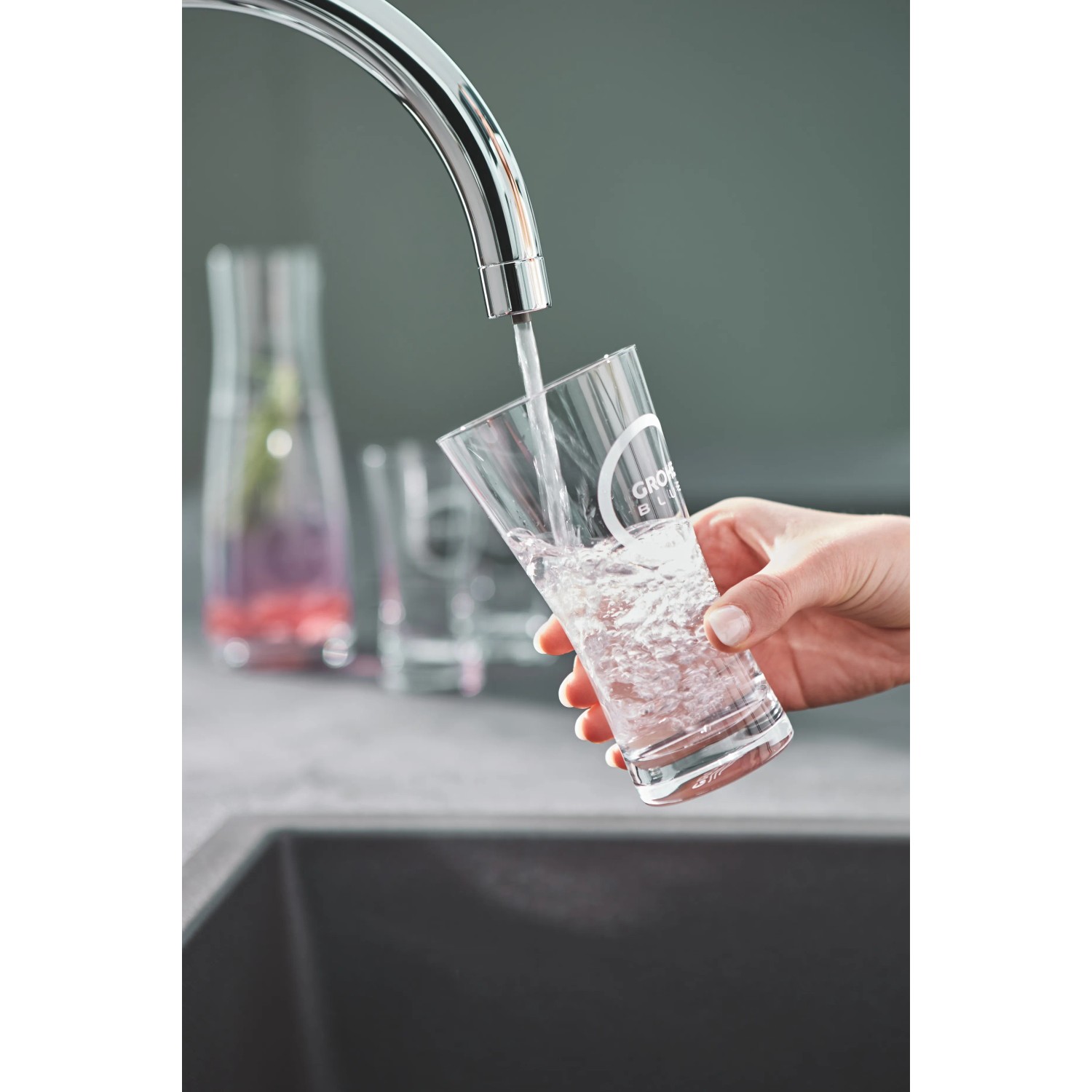 Grohe Blue Pure BauCurve Starter Kit: Rubinetto che riempie il bicchiere con acqua filtrata.