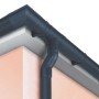 Grondaia e pluviale in plastica grigio scuro su un tetto di casa.