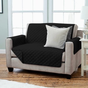 Copridivano trapuntato nero con braccioli e cuscini.