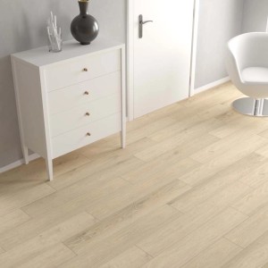 Pavimento vinilico chiaro t.b.t. in soggiorno con comò e sedia.