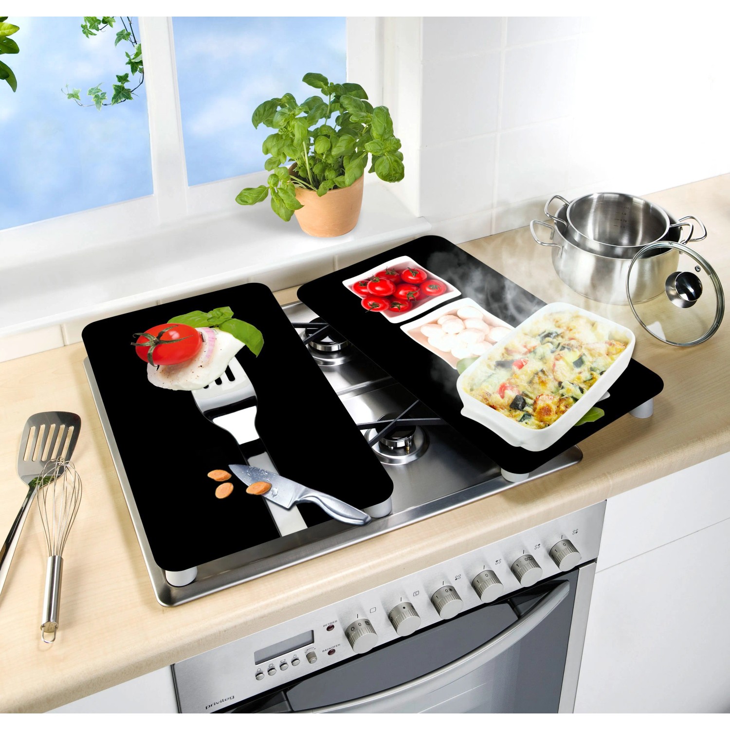 Set di 2 coperture per piano cottura Wenko Caprese su un fornello con motivi di ingredienti italiani.