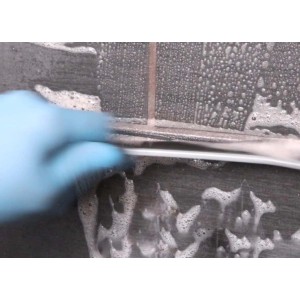 Strumento di pulizia in azione: piastrelle pulite con schiuma e spazzola.