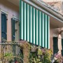 Tenda da sole t.b.t. a strisce bianche e verdi su balcone.