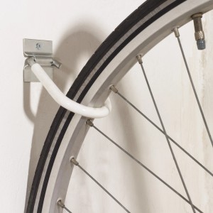 Dettaglio di un gancio per bicicletta zincato per montaggio a parete con pneumatico.