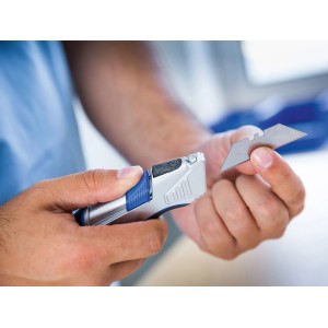 Cutter LUX con custodia e lama in mano, argento con manico blu.