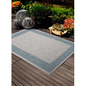 Tappeto da esterno t.b.t. grigio con bordo blu su patio in legno.