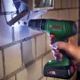Avvitatore a percussione a batteria Bosch 18V con batteria e valigetta in uso per avvitare nella muratura.