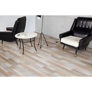 Laminato Comfort Rovere Mixed posato in soggiorno con poltrone e tavolo. Aspetto legno, senza fughe.