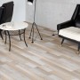 Laminato Comfort Rovere Mixed posato in soggiorno con poltrone e tavolo. Aspetto legno, senza fughe.