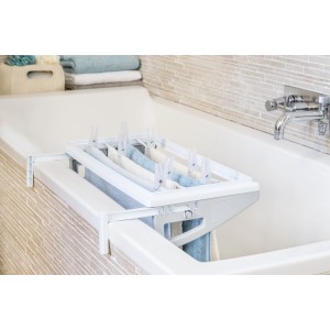 Stendibiancheria bianco t.b.t. per vasca da bagno con bucato e mollette.