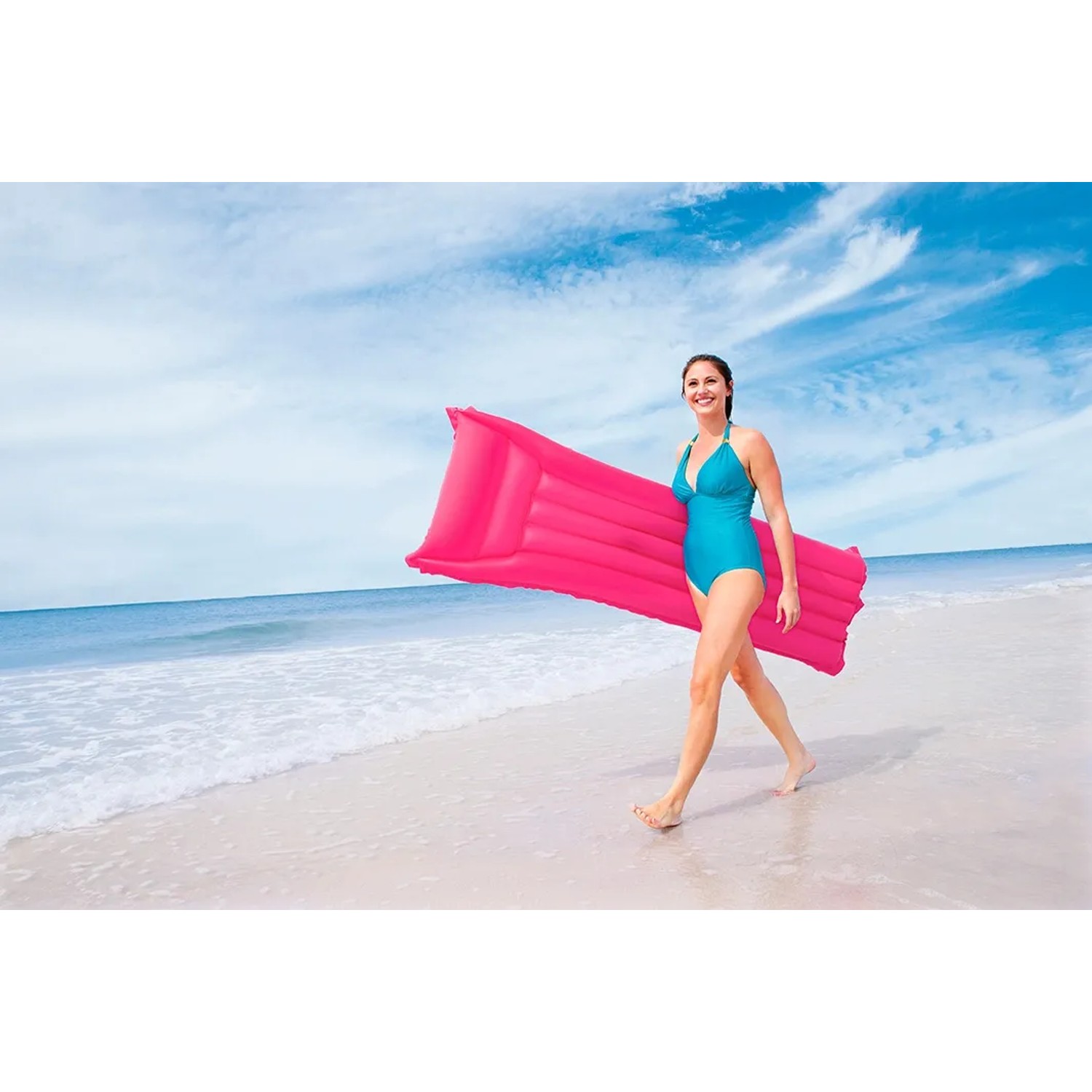 Donna con materassino gonfiabile rosa sulla spiaggia.
