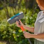 Spazzola Gardena Cleansystem Hard antracite con donna in giardino. Ideale per la pulizia a umido.