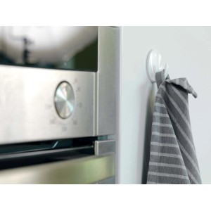 Gancio adesivo bianco con asciugamano a righe grigie in ambiente cucina.