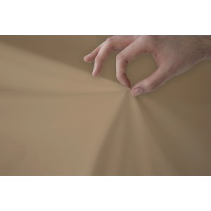 Primo piano di un cuscino/federa t.b.t. beige toccato da una mano.