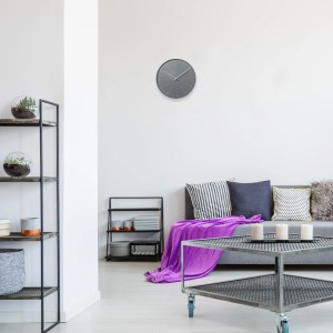 Orologio da parete grigio t.b.t. in soggiorno. Orologio decorativo per la casa.