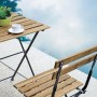 Tavolo e sedia pieghevoli in legno per balcone con struttura in metallo nero.
