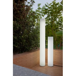 Due luci da esterno t.b.t. bianche a forma di cilindro in giardino.