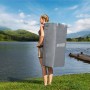 Donna che trasporta il set Bestway SUP Board Aqua Drifter nello zaino al lago.