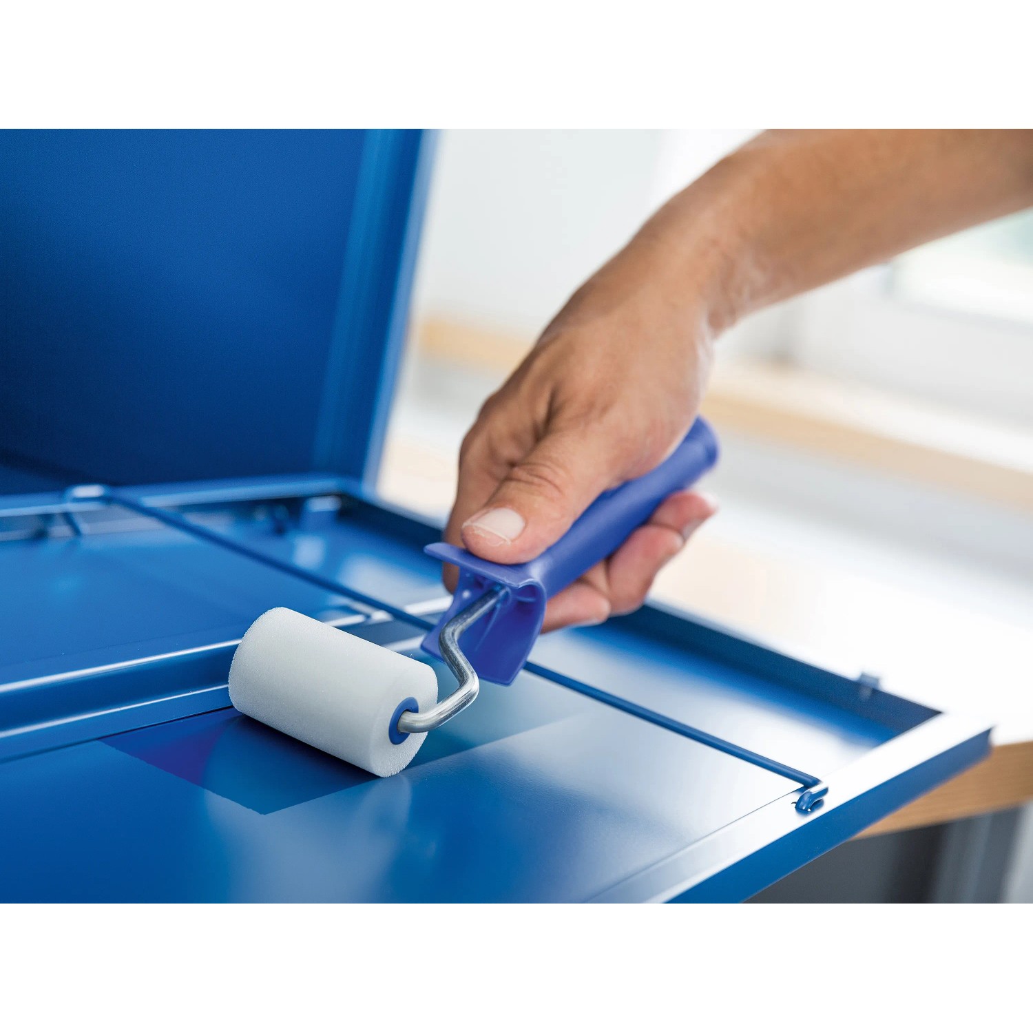 Rullo in schiuma LUX 5 cm, bianco, in uso su superficie blu per risultati di verniciatura fine.
