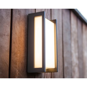Moderna lampada da parete per esterni a LED Lutec Qubo con luce bianca calda su parete di legno.
