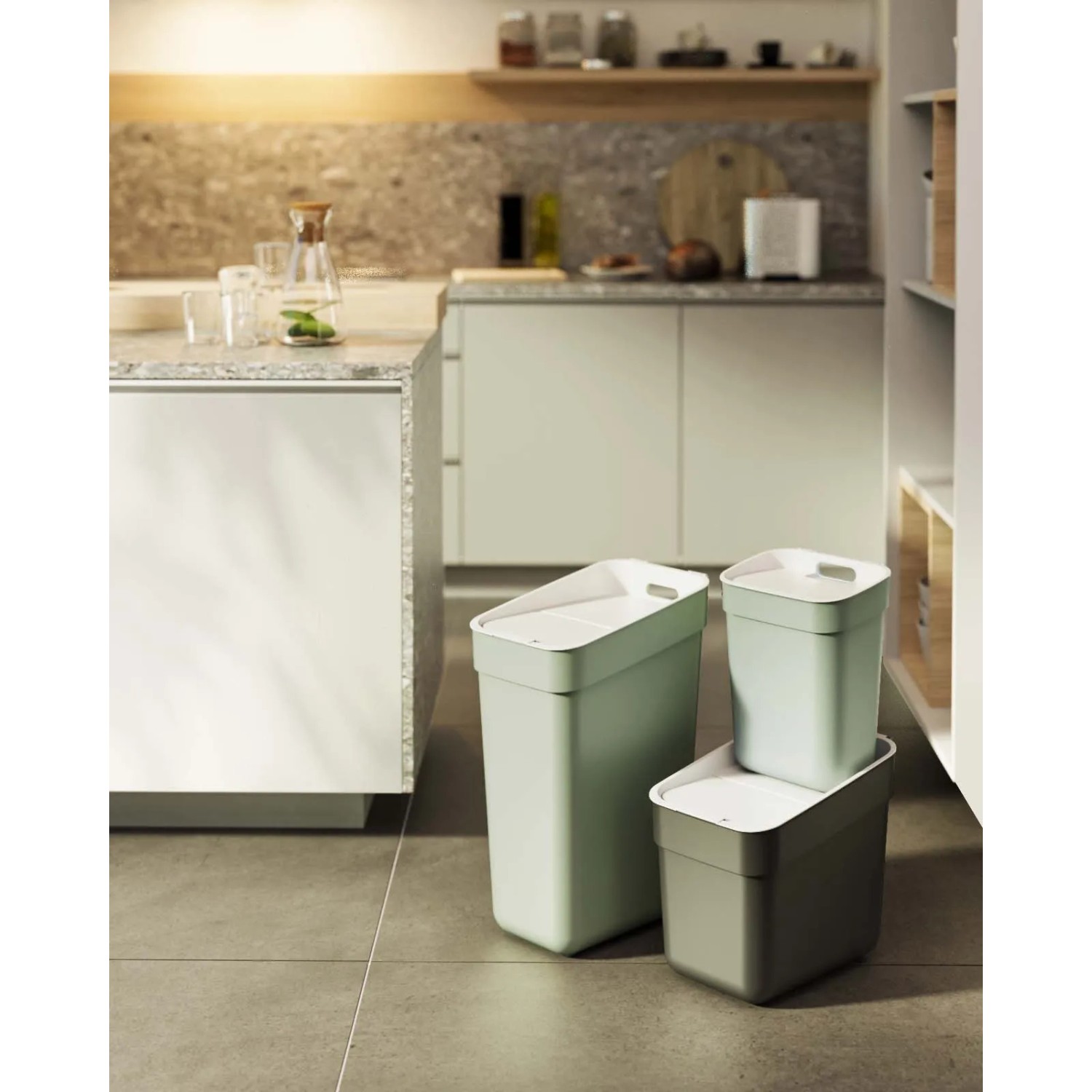 Set di tre pattumiere colorate t.b.t. con coperchio in cucina.