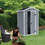 Casetta da giardino Keter Manor 4x3 grigio-bianca con porta aperta e donna che pianta un'aiuola.