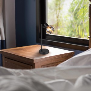 Lampada da scrivania nera t.b.t. con testa in vetro su comodino.