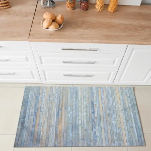 Tappeto da cucina blu effetto legno davanti a mobili da cucina bianchi.