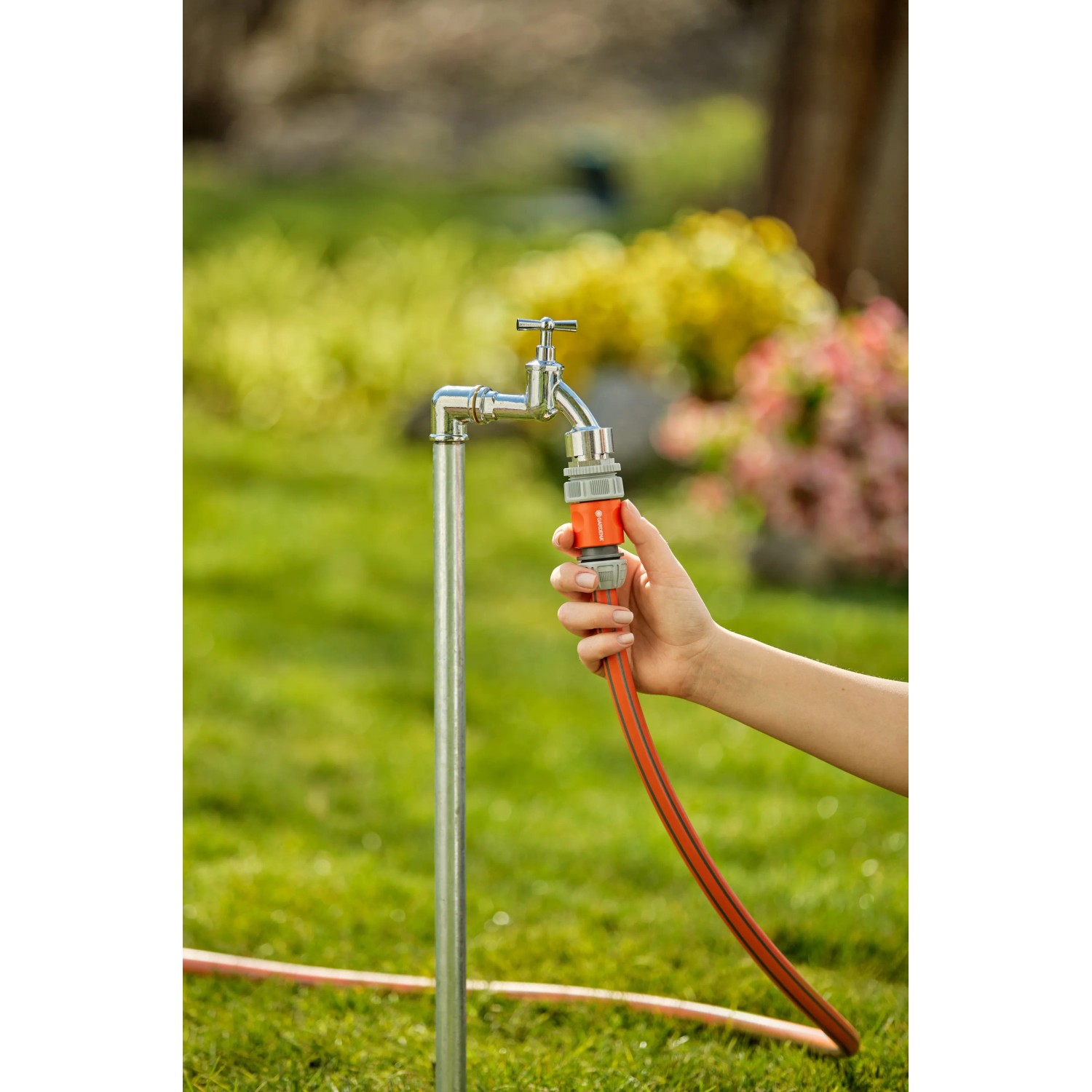 Tubo da giardino collegato a un rubinetto con un raccordo per irrigazione t.b.t.