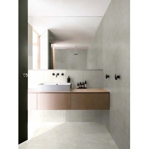 Bagno luminoso con piastrelle per pavimenti t.b.t. e mobile lavabo con specchio.