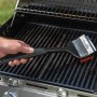 Spazzola per griglia Char-Broil Cool Clean Premium in azione su griglia. Utensile per barbecue con raschietto e gancio.
