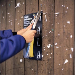 Persona che fissa un poster a una parete di legno con una sparachiodi.