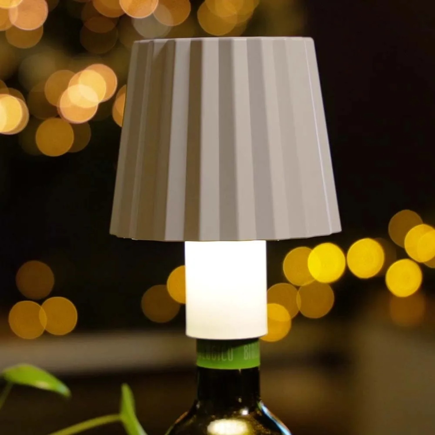 Lampada da tavolo per esterni t.b.t. posizionata su una bottiglia di vino.