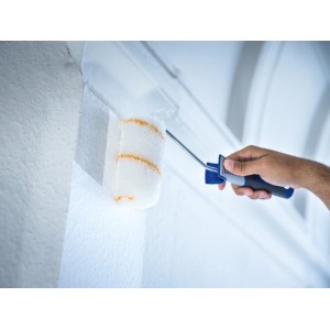 Rullo a dispersione LUX 12 cm con pelo lungo in poliammide mentre dipinge una parete.