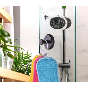 Tre spugne da bagno colorate appese a un gancio nero in una doccia.