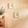 Decorazione parete con guanto creativo: parete beige strutturata con quadri e piante.