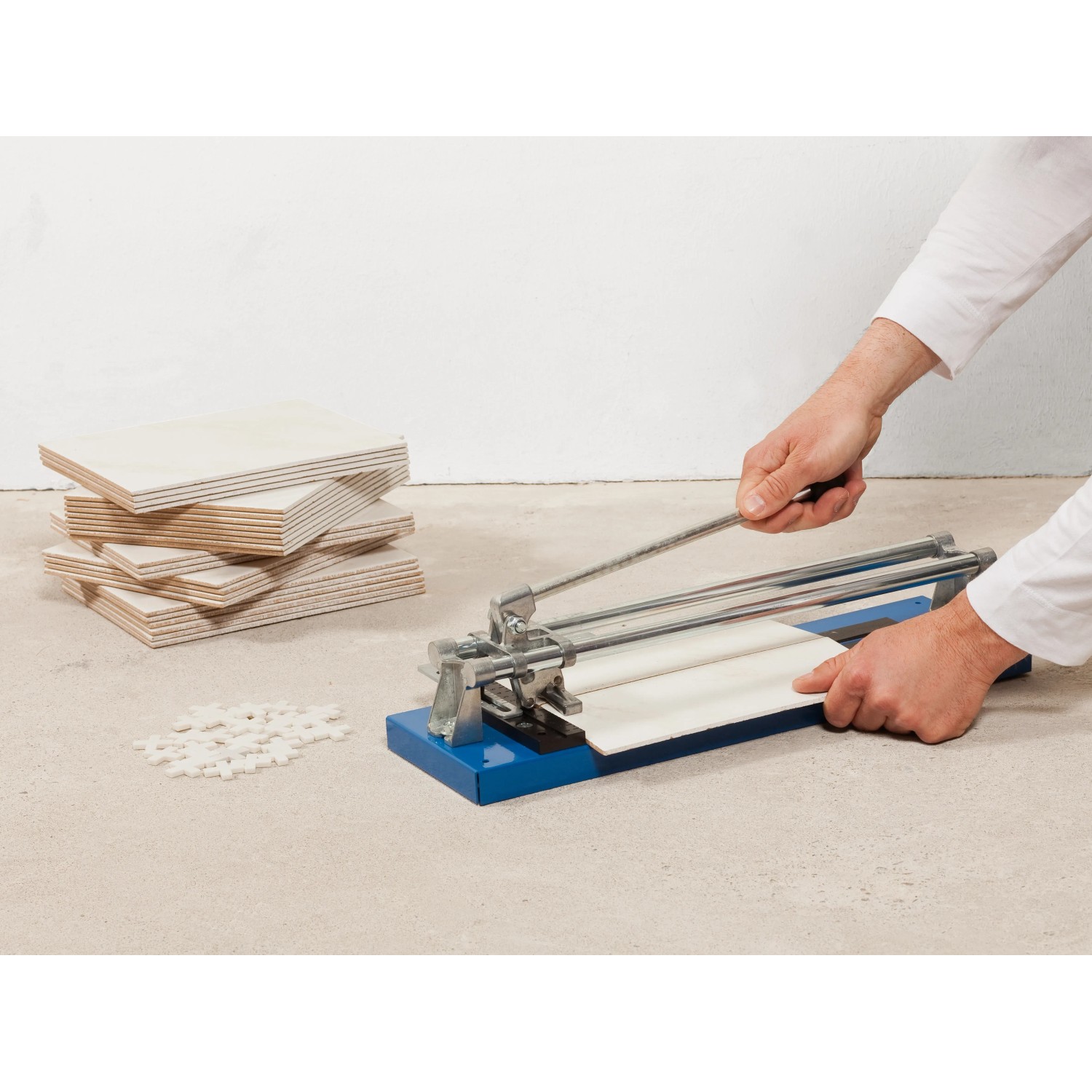 Tagliapiastrelle LUX FSM-330 Classic in azione con pila di piastrelle. Strumento per tagliare piastrelle.