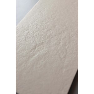 Primo piano di una piastrella per pavimenti chiara con una leggera texture.