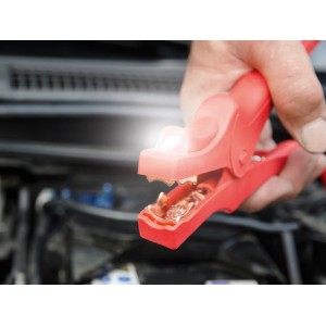 Pinza per cavi di avviamento OBI rossa con illuminazione a LED nel vano motore di un'auto.