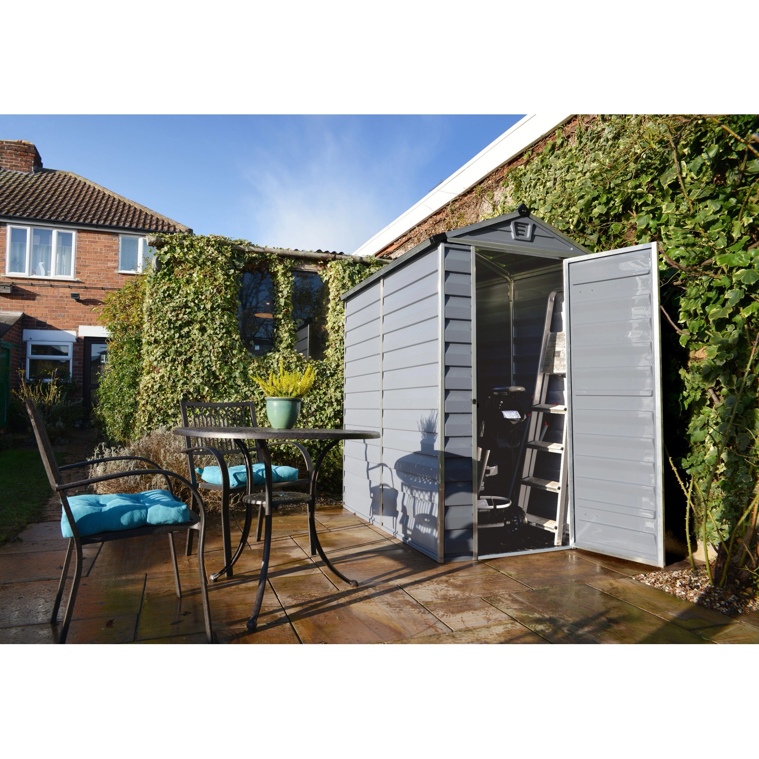 Casetta da giardino in plastica grigia Palram Canopia Skylight 1.2 x 1.8 con porta aperta e scala all'interno.