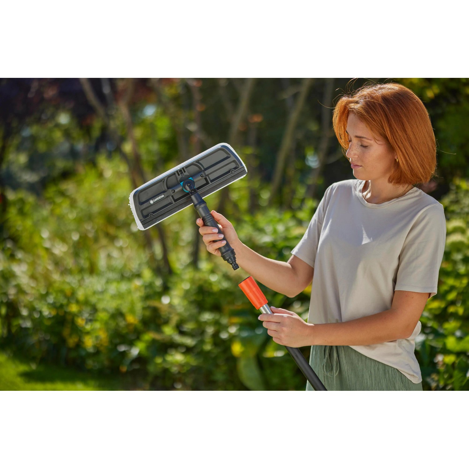 Donna utilizza il tergivetro Gardena Cleansystem con microfibra e labbro.
