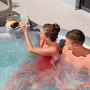 Vassoio Bestway LAY-Z-SPA in uso: coppia si rilassa con bevande nella vasca idromassaggio. Pratico accessorio per vasca idromassaggio.