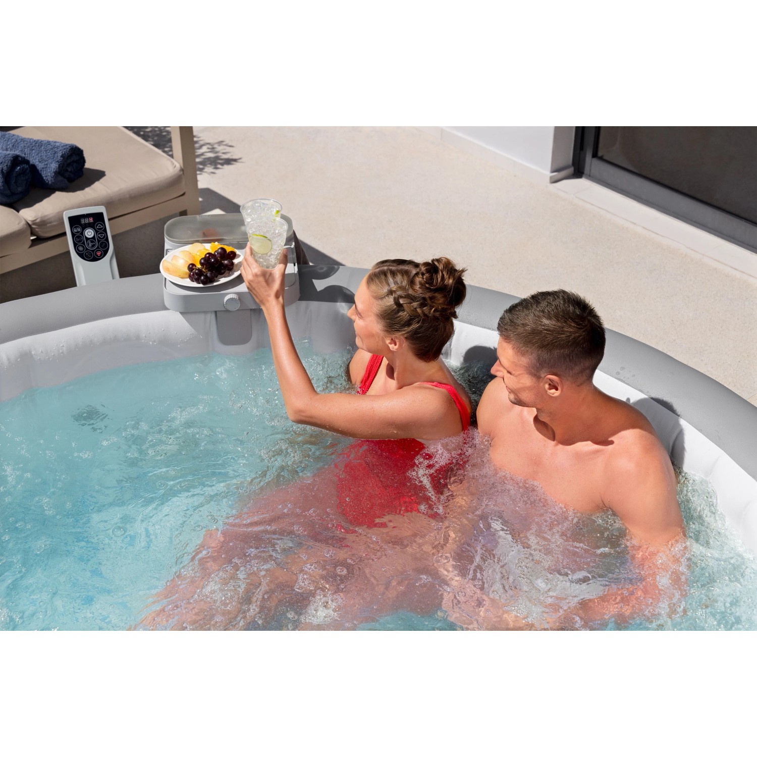 Vassoio Bestway LAY-Z-SPA in uso: coppia si rilassa con bevande nella vasca idromassaggio. Pratico accessorio per vasca idromassaggio.