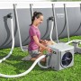 Donna che utilizza la pompa di calore per piscina Bestway a bordo piscina. Riscaldatore con tubi e sistema di filtraggio sul prato.