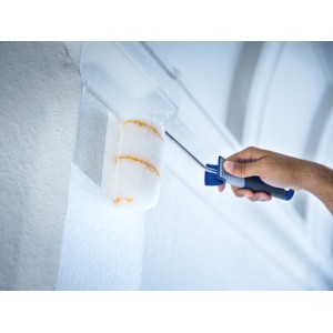 Rullo a dispersione LUX (12 cm) mentre dipinge una parete. Rullo per pittura in poliammide per superfici ruvide.