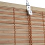 Dettaglio di una tenda a rullo o pacchetto t.b.t. marrone in bambù con sospensione.