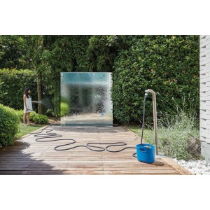 Donna che irriga il giardino con tubo per irrigazione t.b.t. e carrello avvolgitubo.