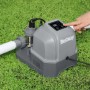 Sistema di trattamento acqua piscina Bestway su erba con mano sul pannello di controllo.